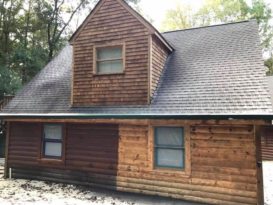 A log cabin with a roof that is covered in shingles